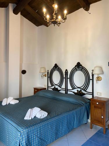 a bedroom with a blue bed with two mirrors at La Locanda del Curato Rooms in Lentiscosa
