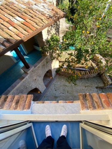 a person standing on a porch with a table and a plant at La Locanda del Curato Rooms in Lentiscosa