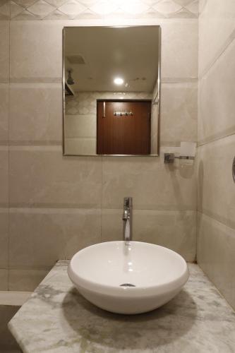 a white sink in a bathroom with a mirror at HOTEL YATRI in Nagpur