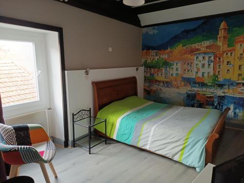 a bedroom with a bed with a painting on the wall at L'orée des 3 Rivières in Is-sur-Tille