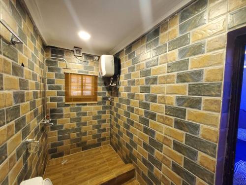 a bathroom with a shower with a stone wall at Vim 2-BR-Apt With Fast Unlimited Internet & 24HRS Power in Lagos