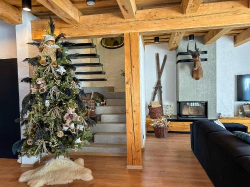 a christmas tree in the middle of a living room at Chalet Black Deer in Mýto pod Ďumbierom