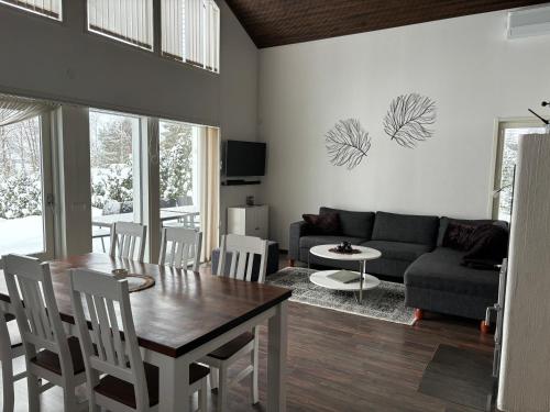 Villa koivula في Rääkkylä: غرفة معيشة مع طاولة وأريكة
