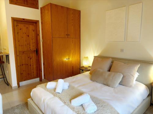 Un dormitorio con una cama blanca con toallas. en Maison Damianou Elegant Loft, en Omodos