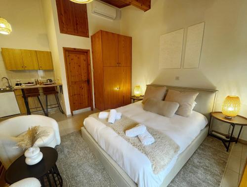 Un dormitorio con una cama blanca con toallas. en Maison Damianou Elegant Loft, en Omodos