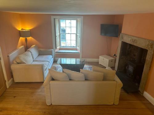 a living room with two couches and a fireplace at Stunning 3 bedroom House with amazing Castle view in Alnwick