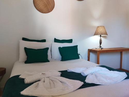 a bedroom with a bed with towels on it at Pousada João Maria in Trancoso