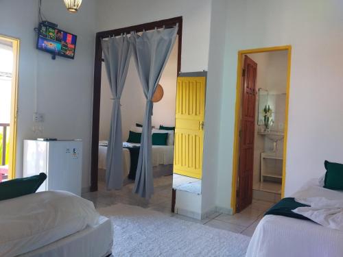 a bedroom with two beds and a door with a mirror at Pousada João Maria in Trancoso