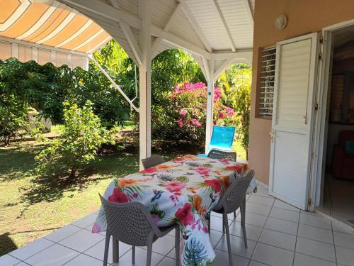 a table on a porch with a laptop on it at Residence Corail in Sainte-Rose