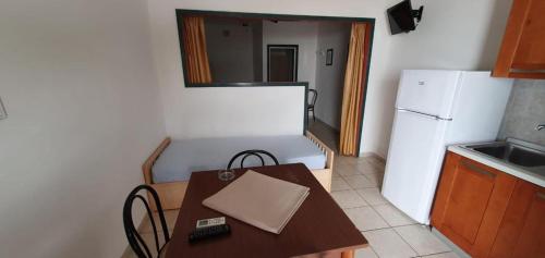 a small kitchen with a table and a refrigerator at Appartamenti Villa Miramare in Capoliveri