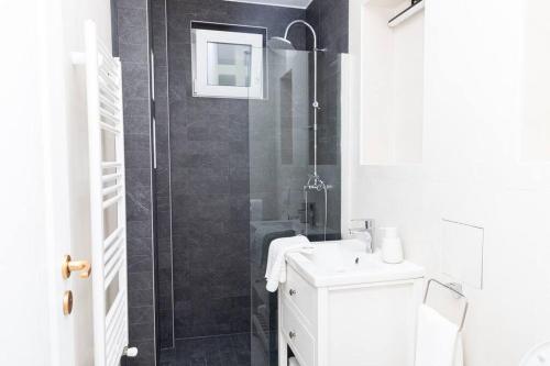 uma casa de banho branca com um chuveiro e um lavatório. em Enescu 3 City Center Flat em Timisoara