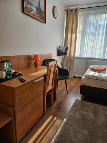 a room with a desk and a bed and a room with a bed sqor at "Hel" Wieniec Zdrój in Włocławek