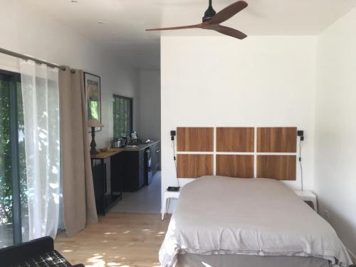 une chambre avec un lit et un ventilateur de plafond dans l'établissement La Cabane, à Bouliac