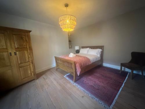 a bedroom with a bed and a chandelier at Stunning 3 bedroom House with amazing Castle view in Alnwick