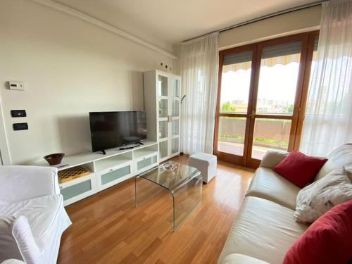 een woonkamer met een witte bank en een tv bij [Incantevole] - 15 Minuti da Duomo + Wifi, Parking in San Donato Milanese