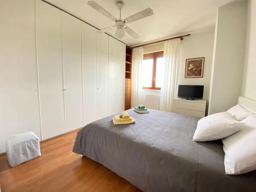 een slaapkamer met een groot bed en een plafondventilator bij [Incantevole] - 15 Minuti da Duomo + Wifi, Parking in San Donato Milanese