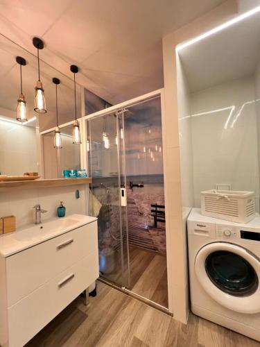 a bathroom with a washing machine and a sink at Apartament Portowy in Hel