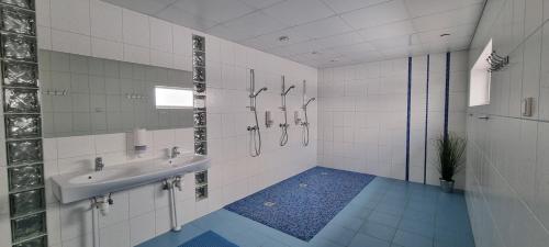 a white bathroom with a sink and a shower at Jõesuu Puhkemaja puhkemaja 6-le in Yyyezu