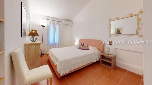 a bedroom with a bed and a chair and a mirror at Appartamento Dream - Cala Granu in Porto Cervo