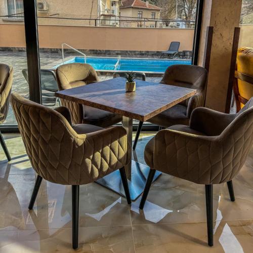 a table and chairs in a room with a pool at Стоичковата къща гр. Стрелча in Strelcha