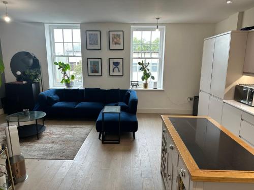 ein Wohnzimmer mit einem blauen Sofa und einem Tisch in der Unterkunft West London Hideaway Suite in Ealing