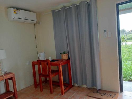 Zimmer mit einem Tisch, einem Stuhl und einem Fenster in der Unterkunft Toafa Lodge in ‘Ohonua