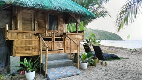 a house on the beach with two chairs and a porch at NATUA'S BEACH RESORT in Liminangoon