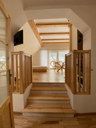 uma escada que leva a um quarto com pisos em madeira em Apartament W Dolinie Modrzewi em Kamienna Góra