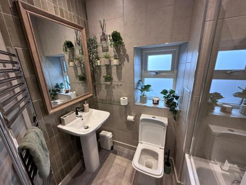 a bathroom with a sink and a toilet and a shower at Prince St Cottage - Haworth - Sleeps 4 in Haworth