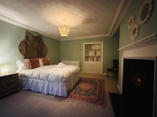 a bedroom with a large bed and a fireplace at Stunning 3 bedroom House with amazing Castle view in Alnwick