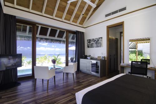 a bedroom with a bed and a view of the ocean at Kandolhu Maldives in Himandhoo 