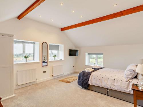 a bedroom with a bed and two windows at 3 Bed in Wintersett 93234 