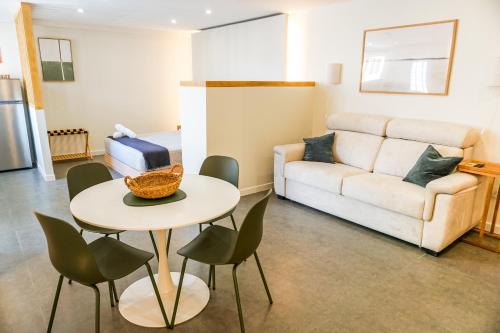 a living room with a table and chairs and a couch at Estudio Suite 408 in Alicante