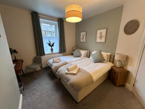 a bedroom with a bed with two towels on it at Prince St Cottage - Haworth - Sleeps 4 in Haworth