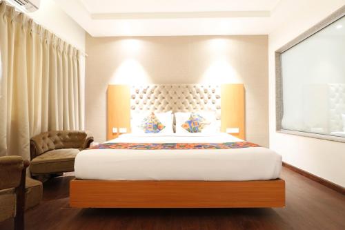 a hotel room with a bed and a chair at HOTEL YATRI in Nagpur