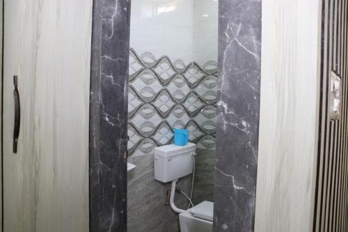 ein Bad mit einem WC und einer Steinmauer in der Unterkunft Green Valley Seas and Resorts in Ranchi