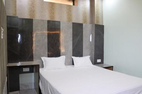 ein Schlafzimmer mit einem großen weißen Bett mit zwei Kissen in der Unterkunft Green Valley Seas and Resorts in Ranchi