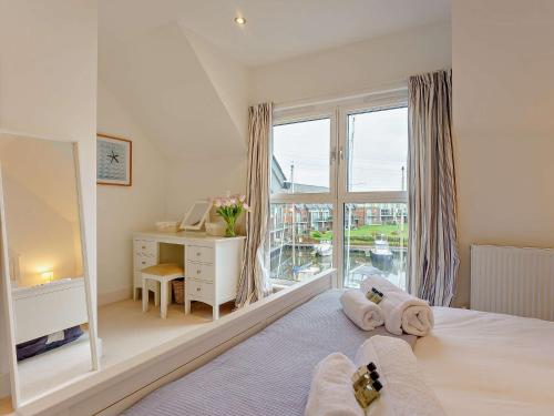新港的住宿－4 Bed in East Cowes 93249，一间卧室配有一张带书桌的床和窗户。