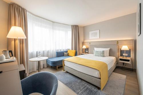 a hotel room with a bed and a chair at Hotel Europa in Munich