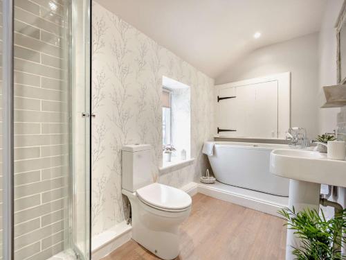 a bathroom with a toilet and a tub and a sink at 2 Bed in Cockermouth 93280 in Bridekirk