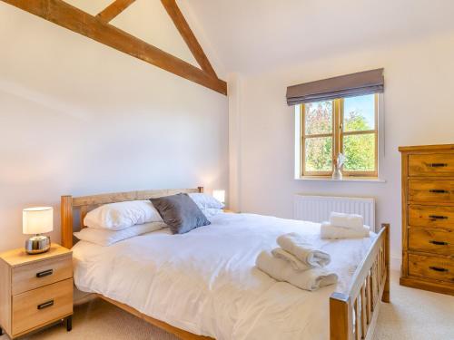 a bedroom with a large bed and a window at 4 Bed in Bishops Offley 93215 in Eccleshall