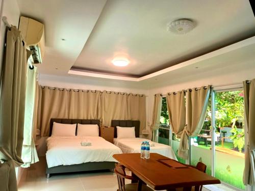 1 dormitorio con 2 camas y mesa en OASIS Phuket Airport, en Ban Bo Sai Klang