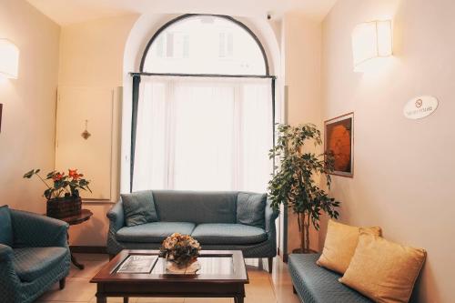 - un salon avec deux canapés bleus et une fenêtre dans l'établissement Hotel Galileo, à Florence