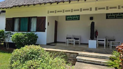 a house with a patio and a table and chairs at Mnarani Beach Club in Kilifi