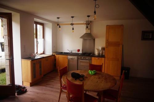 a kitchen with a wooden table and a dining room at belle maison de campagne in Hénon