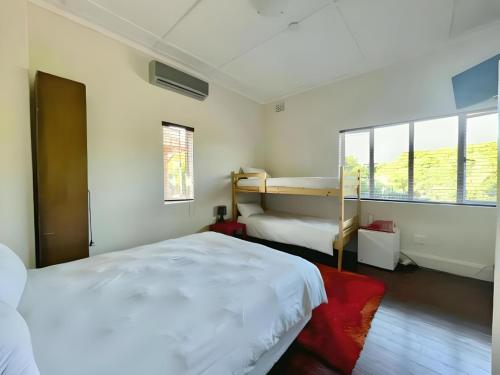 1 dormitorio con 2 camas y ventana en KZN Park View Guest House, en Durban