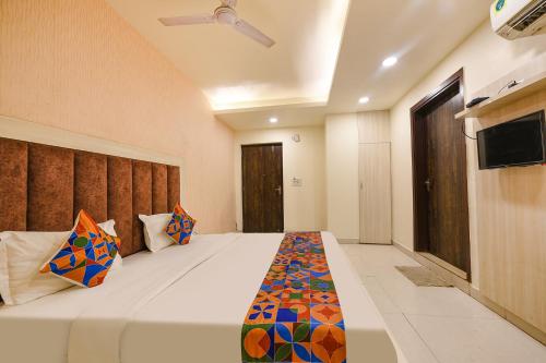 a bedroom with a large white bed with a colorful blanket at FabExpress Seven Heaven in New Delhi