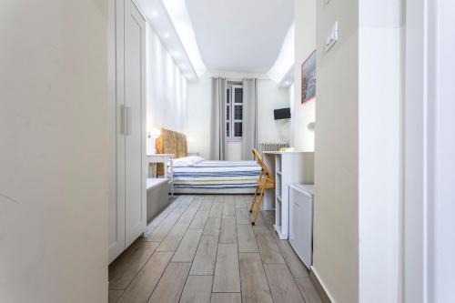 un pasillo con paredes blancas y suelo de madera en Il Guardinfante - Camera indipendente con bagno privato, en Turín