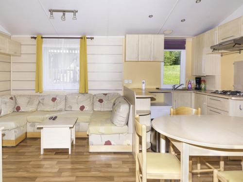 ein Wohnzimmer mit einem Sofa und einem Tisch in der Unterkunft Camping Nature et insolite proche Disneyland in Saâcy-sur-Marne