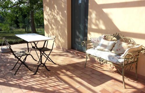 a patio with a table and a chair and a table at B&B Antegiano in Belforte del Chienti